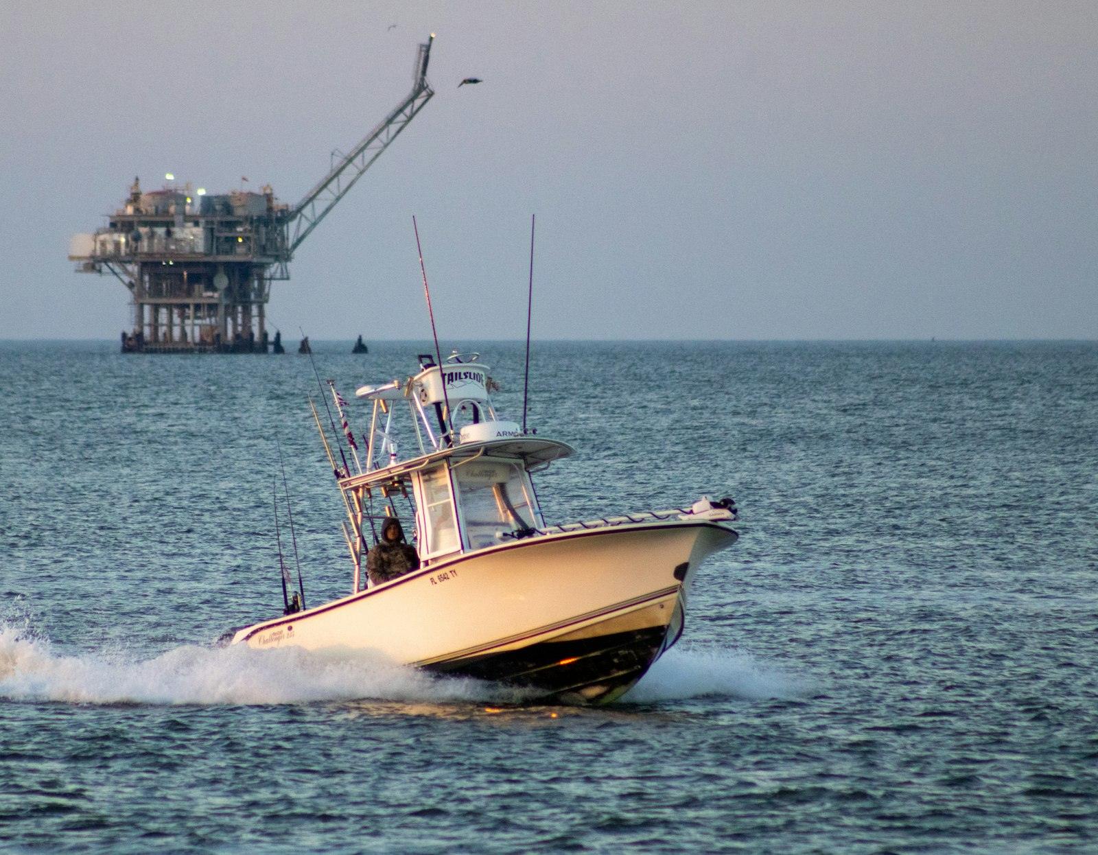 Supply vessel passing an offshore oil platform